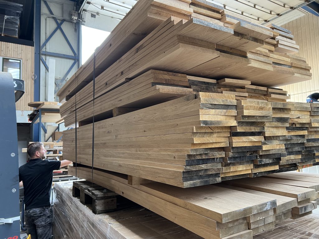Een medewerker van Eikenhouthandel.nl inspecteert hoogwaardige eiken planken voor topkwaliteit